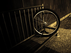 A bike wheel locked to a bike rack.